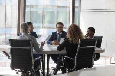 Konferans masasında çeşitli bin yıllık iş grupları beyin fırtınası yapıyor. Girişim liderleri, proje yatırımcıları toplantısı, pazarlama raporlarını analiz, yatırım pazarlığı, anlaşma