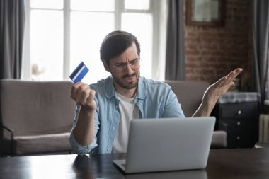 Canı sıkkın banka müşterisi dizüstü bilgisayar kullanıyor, mesaj okuyor, kredi kartıyla ilgili sorunları fark ediyor, banka hesaplarını kapatıyor, harcamaları sayıyor, zarar ediyor, aşırı para harcıyor, iflas ediyor.