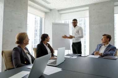 Çeşitli iş adamları yönetim kurulunda toplanıyor, grup toplantısına katılıyor, Afrikalı patron çalışanlarla brifing veriyor, müşteriler için çizelge üzerinde sunum yapıyor, ofis konseptinde ortaklar görüşüyor.