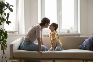 Neşeli genç anne ve sevimli çocuk aile yakınlığı, ilişki, eğlence, burun dokunuşuyla oynamak, gülmek, eğlenmek. Neşeli anne anneliğin tadını çıkarıyor, kızına karşı şefkatli.