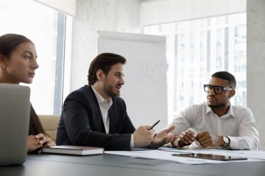 Milenyum çoklu etnik çeşitlilikte iş adamı müzakere masasında modern kurul odasında oturuyor, fikirleri, çözümleri paylaşıyor, iş çözümlerini paylaşıyor, grup toplantısında işbirliği planları yapıyor. Takım çalışması, işbirliği kavramı