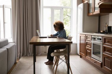 Mutfakta Afrikalı öğrenci masa yazma egzersizi yapar, ses kurslarını dinlerken notlar alır, evde yabancı dil bilgisini geliştirir. Modern teknoloji, e-öğrenme, sınav hazırlığı