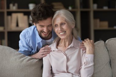 Yakışıklı, gülümseyen, orta yaşlı annesine sarılan, sevgi, destek ve samimi ilgi gösteren, yaşlı mutlu anneye şükranlarını sunan, sıcaklığın ve şefkatli anların tadını çıkaran bir adam. Aile bağları, bağ