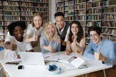 Altı çok ırklı öğrenciden oluşan bir grup üniversite kütüphanesinde toplandı ve kameraya gülümseyip başparmaklarını kaldırdılar. Hazırlık sınavları, yüksek kurumda eğitim, takım çalışması, arkadaşlık, başarı konsepti