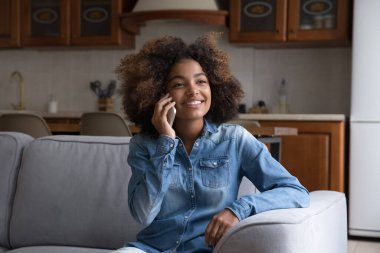Afrikalı kız koltukta oturuyor, kaygısız ergen akıllı telefonda konuşmaktan hoşlanıyor, erkek arkadaşla hoş sohbetler yapıyor, haberleri paylaşıyor, planlama haftasonu mutlu hissettiriyor. Modern teknoloji kullanılarak iletişim