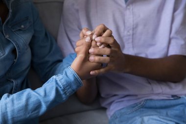 Kimliği belirsiz Afrikalı kız ve erkek koltukta el ele tutuşuyorlar. Yaklaş. Güvenilir bir konuşma, duygularınızı paylaşın ve aşkınızı ilan edin, arkadaşınıza psikolojik destek verin. Romantik ilişkiler, bağ