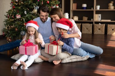 Mutlu bin yıllık anne ve babalar kardeş iki çocuğa Noel hediyesi veriyor. Heyecanlı küçük çocuklar hediye kutularını açıp Noel ağacında dinleniyorlar. Aile kış tatilini kutluyor