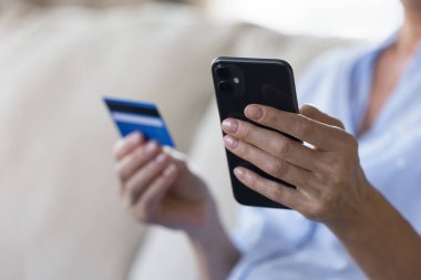 Güvenli e-ödeme, elektronik ticaret, ekommerce müşterisi çevrimiçi alım satım yapıyor. Bilinmeyen kadın ellerini bankamatik kartı ve akıllı telefon ile kapat, online alışveriş yap, mobil uygulama üzerinden para transfer et