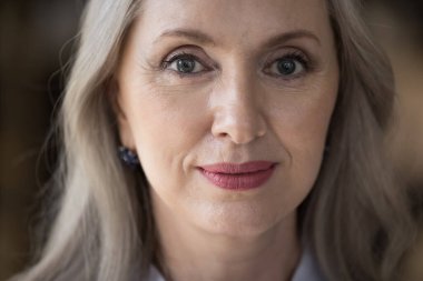 Mutlu son sınıf güzeli kadın yüz portresini kapat. Çekici gri saçlı emekli bayan, emekli, yaşlı olgun kadın model kameraya bakarak poz veriyor. Kırpılmış atış