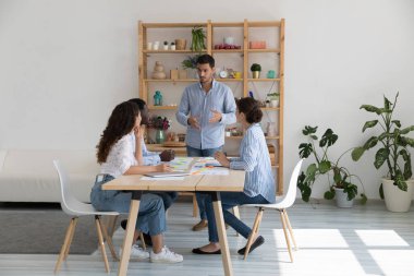 Çeşitli gruplar toplantı odasında toplanır, ortak proje hakkında konuşur, görev hakkında konuşur, ciddi görünür, ilgilenir, ekip lideri personel önünde konuşma yaparken dinler. Brifing etkinliği konsepti