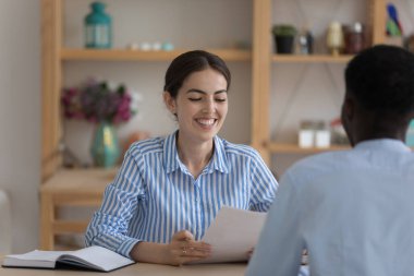 İş görüşmesi süreci, insan kaynakları ve ajans işi kavramı. Çekici İK yöneticisi Afrikalı erkek başvuru sahibi ile görüşüyor. Sorular soruyor, ilk izlenimden memnun görünüyor.