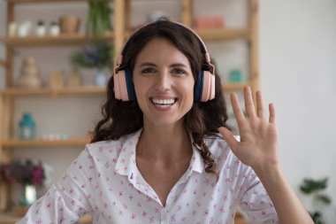 İspanyol iş kadını kablosuz kulaklık takıyor kameraya gülümsüyor müşteriyi selamlıyor ya da iş görüşmesine başlıyor, vesikalık portre çekiyor. Uzaklık görüşmeleri, modern teknoloji, video çağrı etkinliği kavramı