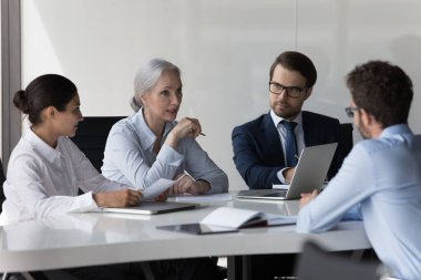 Çeşitli ekip toplantıları, iş başvurusu için adaylarla görüşmeler. İK çalışanları arıyor, yeni eleman alıyor, konferans masasında oturmuş iş tecrübelerini tartışıyorlar.