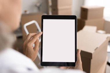 Küçük işletme sahibi, depo çalışanı tablet kullanıyor, envanteri yönetiyor, işlem emirleri veriyor, lojistiği koordine ediyor, müşteriyle iletişim kuruyor, beyaz model ekranlı, kadın omzunun üstünden bakıyor, kapatılıyor.