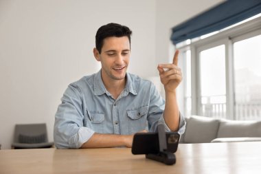 Akıllı telefon web kamerasında konuşan pozitif Latin koç, webinar veriyor, iş eğitimi veriyor, izleyicilere İnternet 'te öğretiyor, telefonu kendi kendini çekmek için kullanıyor, konferansta sohbet ediyor.