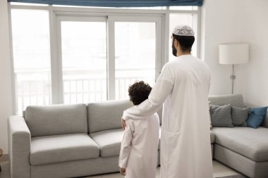 Arap babayı önemseyen, çocuğu kucaklayan, sevgiyle omuza veren, destek olan, pencereden bakan, aile geleceğini düşünen, küçük bir çocuk yetiştiren, emlak yatırımı yapan