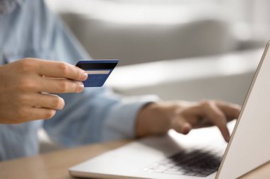 Çevrimiçi ödeme için kredi kartı ve bilgisayar kullanan erkek banka müşterisi, web alımları, finans kontrolü, çevrimiçi banka başvurusu, ekommerce platformundan alışveriş. Eller yukarı, kırpılmış atış.