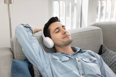 Kaygısız, sakin, iri kulaklıklı İspanyol bir adam. Ev koltuğunda dinleniyor. İnternette sakin melodiler dinliyor.