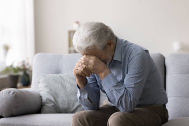 Depresyondaki yaşlı adam kanepeye oturur, ağlar, elleriyle yüzünü kapatır, derin bir çaresizlik hisseder, keder hisseder, sevilen bir ölüm, kötü haber, yalnızlıktan acı çeker. Bozukluk, depresyon, kayıp