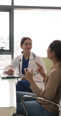 Kadın hasta, profesyonel sağlık hizmeti almak ve etkili bir tedavi planı almak için özel kliniğe yaptığı ziyarette ilgili genç bayan doktorlara semptomları ve sağlık endişelerini paylaşıyor. Sağlık hizmetleri