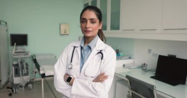 Hintli terapist, iş yerindeki dolapta kollarını kavuşturarak duran üniforma giyer, gülümser, kameraya bakar, iş gününün, görevinin ve mesleki başarılarının tadını çıkarır. Hastane personeli portresi