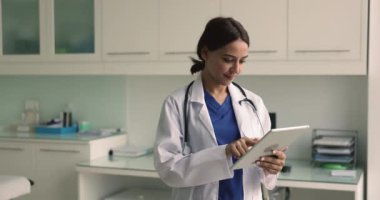 Dijital tablet kullanan kadın kardiyologların çalışma akışı, kardiyak test sonuçlarını gözden geçirme, hastalarla, iş arkadaşlarıyla veya sağlık görevlileriyle iletişim kurma, ilaç yazma, hastanın ilerlemesini uzaktan takip etme