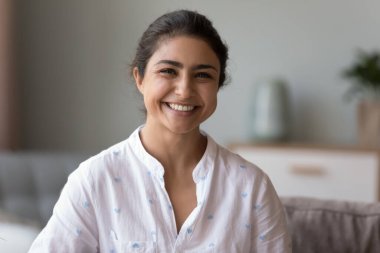 Kafadan çekilen mutlu Hintli kadın kanepeye oturur gülümseyerek kameraya bakar. Genç bayan evdeki kanepede dinlenip gülerek yeni, kendi kiralık modern dairede tasasız hafta sonunun tadını çıkarıyor. Kiracı, duygu konsepti