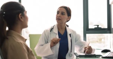 Becerikli kadın doktor pratisyen doktor tavsiyeler ve profesyonel tavsiyeler veriyor, ilaç yazıyor, genç kadın hasta sorularına cevap veriyor, klinikte görüşüyor. Sağlık hizmetleri