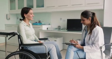Engelli bir kadın tekerlekli sandalyede oturup terapistle konuşur, semptomları açıklar, hastanede sorulara cevap verir. Cerrah ameliyattan sonra sağlık hakkında soru sorarken not alır, hasta şikayetlerini dinler