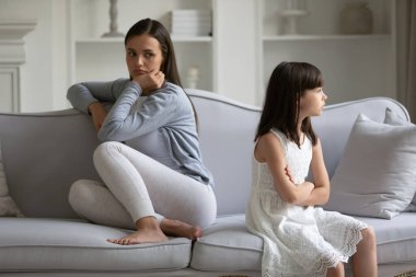 Mutsuz genç anne ve inatçı küçük kız kollarını kavuşturup birbirlerini görmezden geliyorlar. Evdeki kanepede sırt sırta oturuyorlar. Ebeveyn ve çocuk.