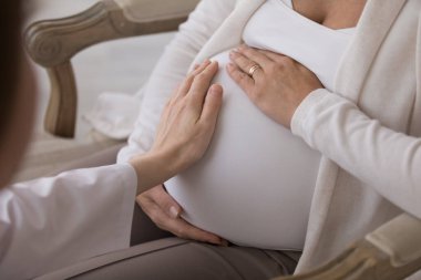 Antenatal bakım, sağlık kontrolü, doğum öncesi test konsepti. Doula 'yı ya da doğum uzmanı-jinekoloğu kapatın. Yardım ve destek verin. Müstakbel anne, eve geldiğinde karnına dokunuyor.