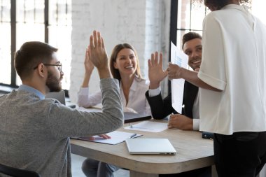 Şirket yöneticisi, bir grup çalışanı şirket toplantısında iş meseleleriyle ilgili oy vermeye teşvik ediyor. Mutlu gülen işçiler oy birliğiyle yönetmeni destekliyor ve yeni önerilere olumlu tepki veriyorlar.