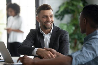 Banka müdürü Afrikalı müşteriyle el sıkışıyor. Gülümseyen mali danışman müşteriye güvendiği için teşekkür ediyor. Genç ve mutlu girişimciler anlaşmaya varıyor. CEO, modern şirkete yeni işçiyi hoş karşıladı