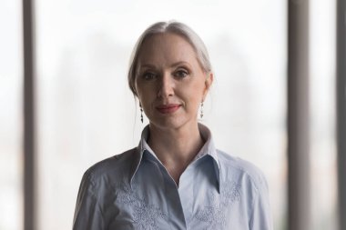 Çekici, kendinden emin orta yaşlı iş kadını pozu. Ofiste gülümse. Kameraya bak. Proje lideri portresi, kariyer büyümesi, liderlik, başarılı şirket üyesi, güvenilir danışman konsepti