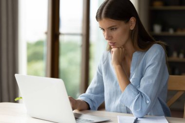 Ciddi düşünceli kadın çalışanlar dizüstü bilgisayarda iş üzerinde düşünüyor, mesaj okuyor, derin düşüncelere dalmış, online uygulamayı bilgisayar üzerinde kullanıyor. Odaklanmış öğrenci kız Webinar öğreniyor.