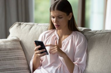 Endişeli genç bir kadının cep telefonuyla sorun yaşaması, başvuru yanlış iş, kötü bağlantı, yazılım hatası, akıllı telefon kullanımı, spam alımı, stres, bıkkınlık, bıkkınlık...