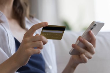 Kapalı çekimler, kimliği belirsiz kadınların elinde kredi kartı ve akıllı telefon, güvenli elektronik ödeme, para harcamak, mal satın almak, e-servis, evde alışveriş. Güvenli e-ödeme, e-banka uygulama kavramı