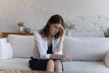 Genç kız, üzgün mutsuz genç kadın evinde kanepede oturuyor. Stresli görünüyor. Umutsuz görünüyor. Ayrılma konsepti