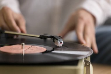 Bilinmeyen bir kadın, eski moda ekipmanlarla vinil plak çalan eski bir pikapta en sevdiği müziği dinliyor. Eski tarz müzik severler için klasik melodi, boş zaman, nostaljik ruh hali