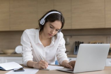 Ciddi bir genç kadın sınav yazar, müzik dersini dinler çevrimiçi çalışmalara katılır, yeni bilgiler kazanır, uzaktan ev mutfağındaki masada oturur. Modern teknoloji, eğitim ve eğitim kullanılarak etkili bir e-öğrenme