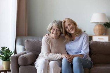 Mutlu, yaşlı bir anne ve neşeli, olgun bir kız evdeki koltukta birlikte oturup sevgi, ilgi, minnettarlık, şefkat, el ele tutuşmalar, kameraya bakmalar, gülümsemeler. Gülüyor