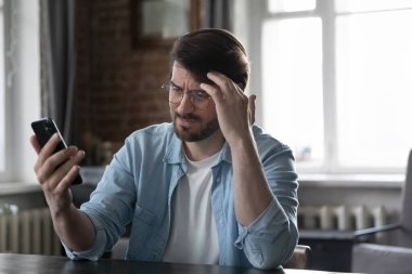 Endişeli akıllı telefon kullanıcısı üzgün yüzüyle cep telefonu ekranına bakıyor, çevrimiçi uygulama, bankacılık hizmeti ile ilgili problemler yaşıyor, kötü haber alıyor, kötü bağlantı hakkında stres hissediyor.