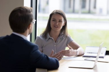 Pozitif iş kadını işe alım için iş görüşmesi yapıyor. İş arkadaşları ofis masasında dizüstü bilgisayarla konuşuyor, projeleri tartışıyor, görevler üzerinde birlikte çalışıyorlar. Müşteri danışmanı.