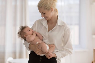 Sevgi dolu genç bir anne kucağında bebek bezi içindeki 0-6 bebeğini sakinleştirir. Birlikte vakit geçirir. Sevgiyi hissettiği anın tadını çıkarır. Anne olmak, mutlu annelik kavramı.