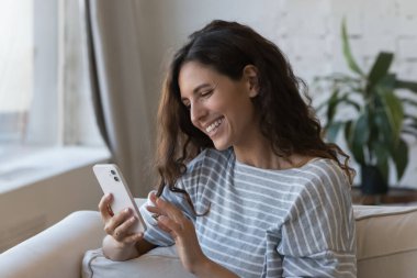 Mutlu, güzel, yetişkin bir Latin kadın cep telefonu kullanmaktan, sohbet etmekten, video aramasından, internet uygulamasından, interaktif hizmetten, kablosuz iletişimden, kahkahalardan hoşlanıyor.