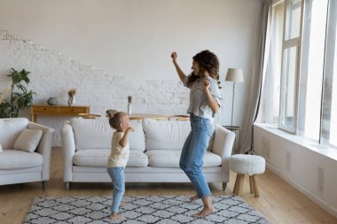 Enerjik ince anne dansçısı küçük tatlı kızına evde dans etmeyi öğretiyor, birlikte şarkı söylüyor, modern dansı müzik eşliğinde öğreniyor, ev aktivitelerinin keyfini çıkarıyor, eğleniyor, eğleniyor.
