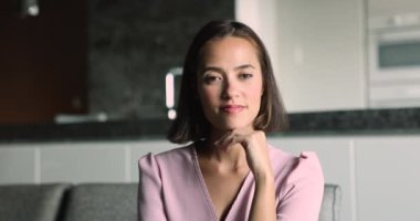 Asyalı genç ve güzel bir manken çenesine, cildine dokunuyor, mutlu oluyor, neşeli, dişlek gülüşüyle kameraya bakıyor, kusursuz beyaz dişlerini gösteriyor, vesikalık portre için poz veriyor.