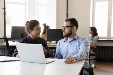 Çeşitli iş arkadaşları dizüstü bilgisayardaki proje görevlerinde işbirliği yapıyorlar, çalışma masasında oturuyorlar, konuşuyorlar, iletişim kuruyorlar, strateji tartışıyorlar, online başlangıç sunumu yapıyorlar. Kurumsal danışman öğretmenlik öğrencisi