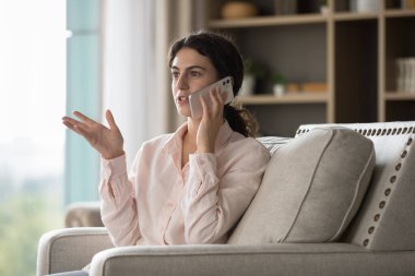 Meşgul meşgul genç İspanyol kadın cep telefonuyla konuşuyor, arama yapıyor, oturuyor, sohbet sırasında koltukta dinleniyor, sorunları tartışıyor, problem, iş projesi. İletişim konsepti