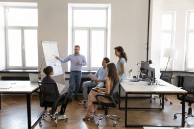 Takım lideri pazarlama raporunu, proje sunumunu, yeni yaratıcı fikirler üzerine beyin fırtınası yapmayı, yönetim kurulunda buluşmayı dinleyen ciddi çeşitli iş arkadaşları. Tam boy, geniş açı.